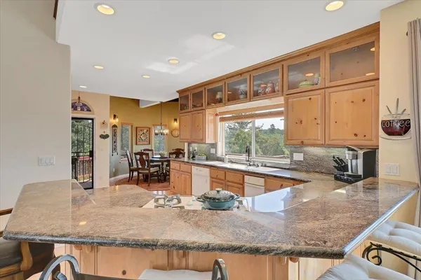 a view of a house with a yard plants and large tree