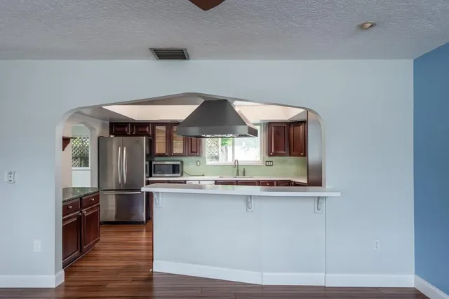 a view of a hallway with wooden floor and closet