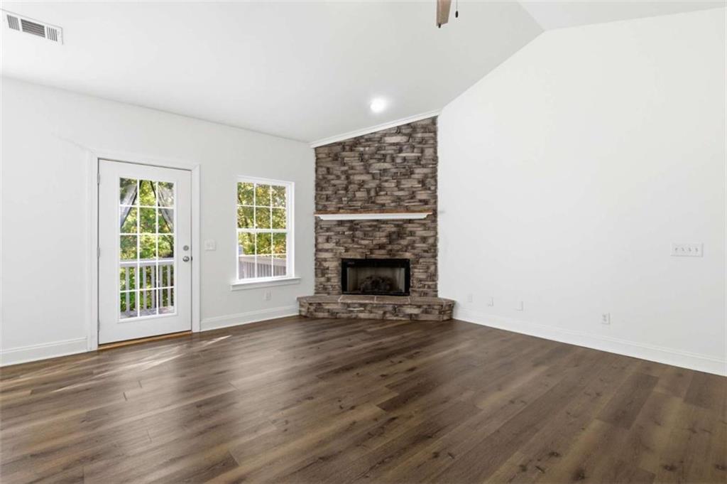 622 Spring Crest Road Cleveland, GA 30528 - Photo 8 of 48 an empty room with wooden floor fireplace and windows