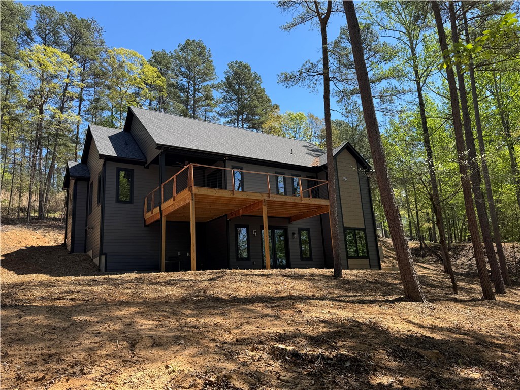 This modern home features a spacious deck, ideal for enjoying the surrounding natural landscape.