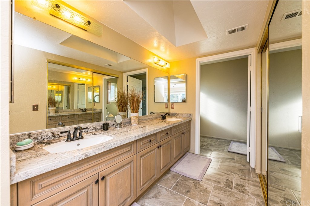22041 Windtree Avenue Wildomar, CA 92595 - Photo 24 of 47 a spacious bathroom with a granite countertop sink mirror and a