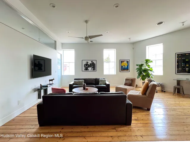 a living room with furniture wooden floor and a flat screen tv