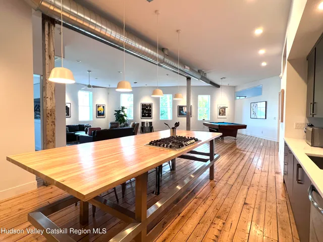 a room with pool table and wooden floor
