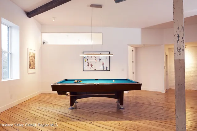 a room with pool table and windows
