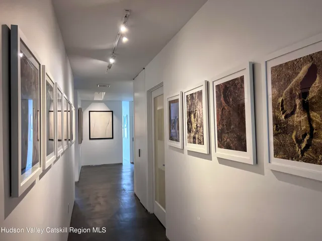 a view of a hallway with wooden floor and windows
