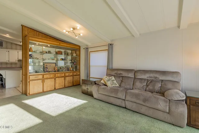 a kitchen with stainless steel appliances kitchen island granite countertop a table chairs and a refrigerator