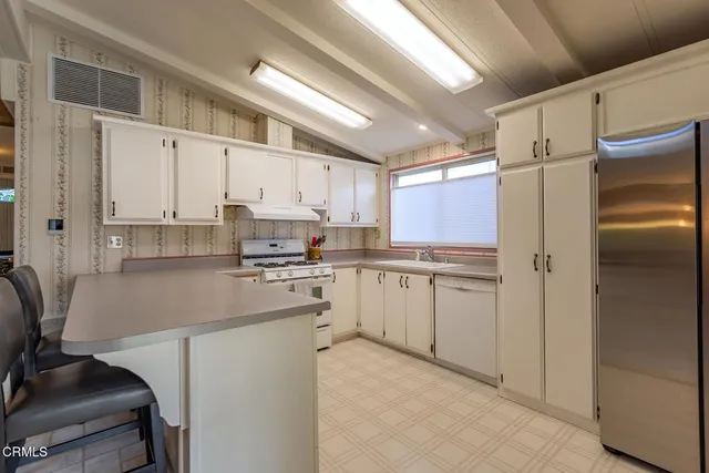 a kitchen with white cabinets and white appliances