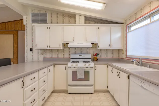 a kitchen with granite countertop white cabinets and white appliances