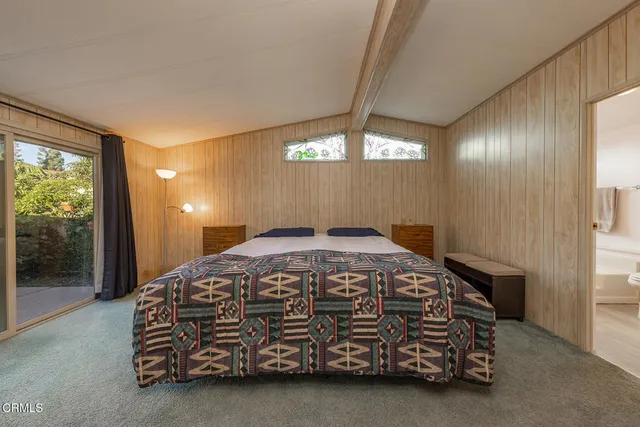 a bedroom with a bed and large window