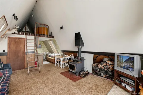 a living room with furniture a flat screen tv and floor to ceiling window