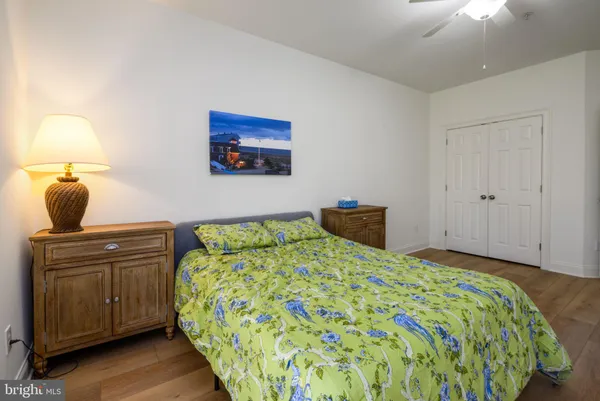 a bedroom with a bed and a lamp on dresser
