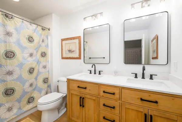 a bathroom with a double vanity sink mirror and toilet