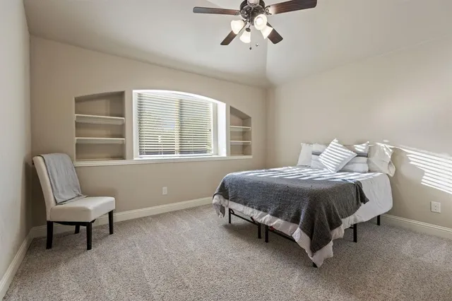 a spacious bedroom with a bed chair and window