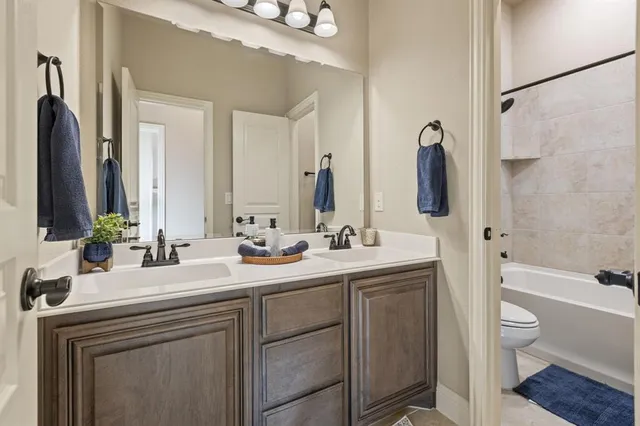 a bathroom with a double vanity sink toilet mirror and shower