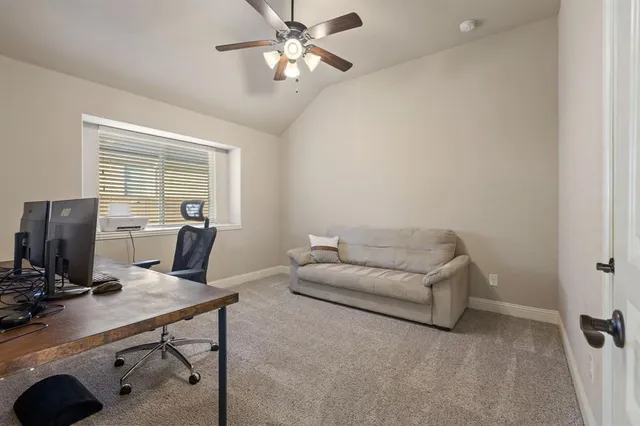 a view of a workspace with furniture and a window