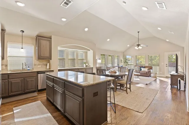 a kitchen with counter top space sink stove and wooden floor