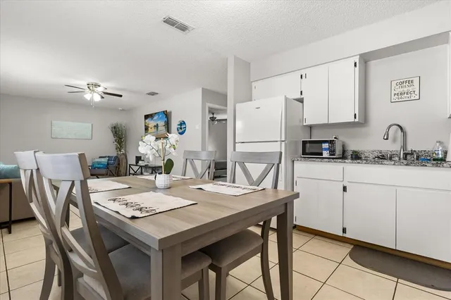 a kitchen with stainless steel appliances granite countertop a refrigerator sink and white cabinets