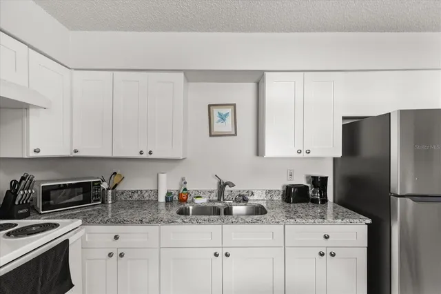 a kitchen with a white cabinets and white appliances