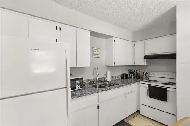 a kitchen with stainless steel appliances granite countertop a refrigerator sink and cabinets