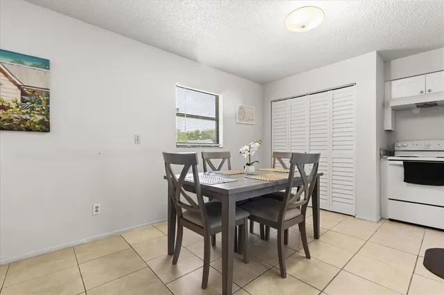 a kitchen with white cabinets and chairs