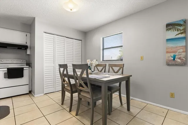 a kitchen with stainless steel appliances granite countertop a dining table chairs and refrigerator