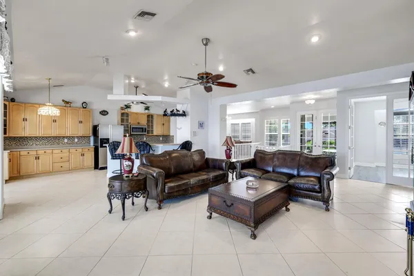 a living room with furniture kitchen view and a chandelier