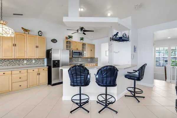 a kitchen with stainless steel appliances kitchen island granite countertop a refrigerator and cabinets