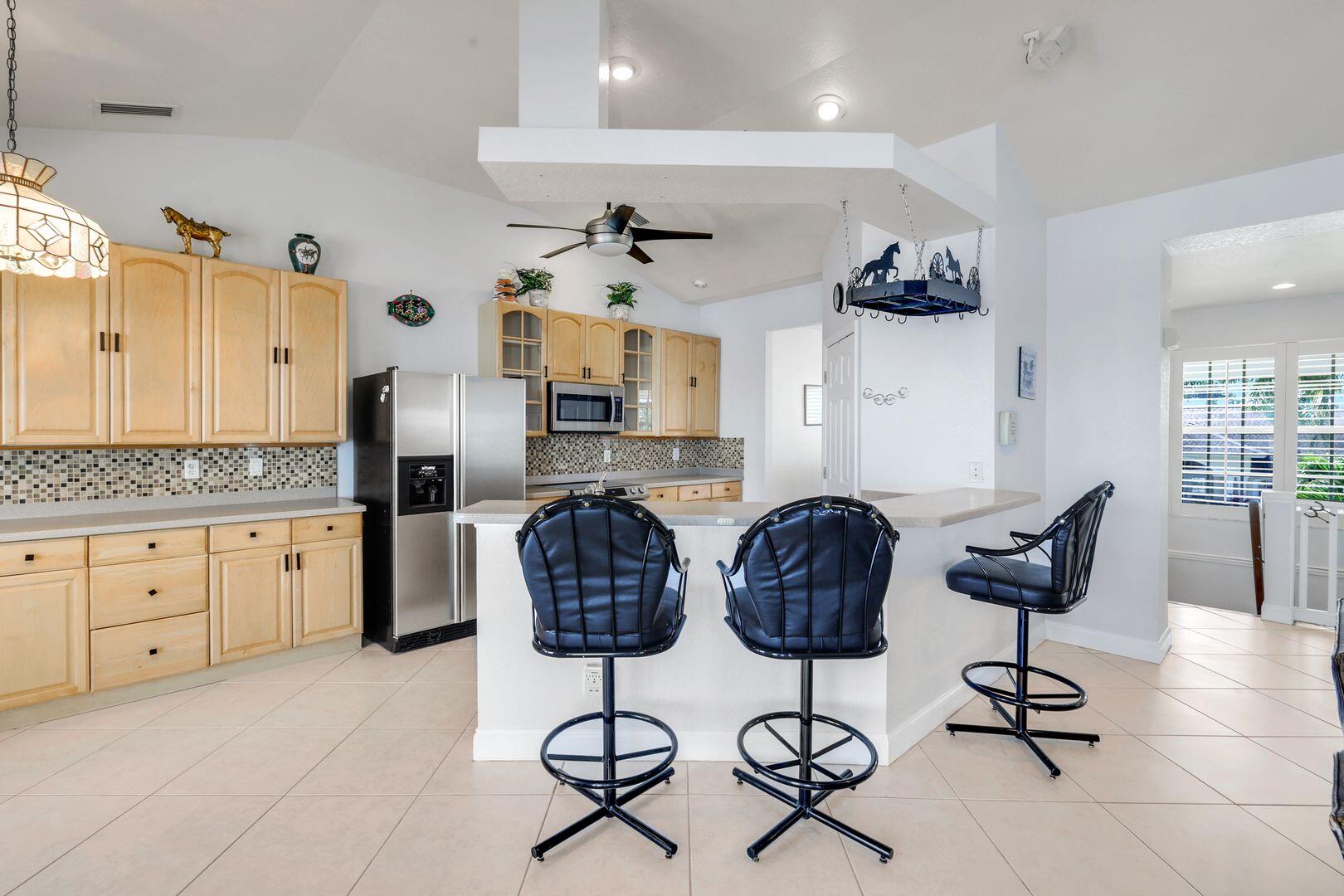 183 Sunset Cay Naples, FL 34114 - Photo 14 of 45 a kitchen with stainless steel appliances kitchen island granite countertop a refrigerator and cabinets