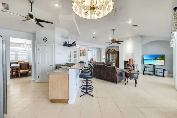 a living room with furniture a chandelier and a flat screen tv