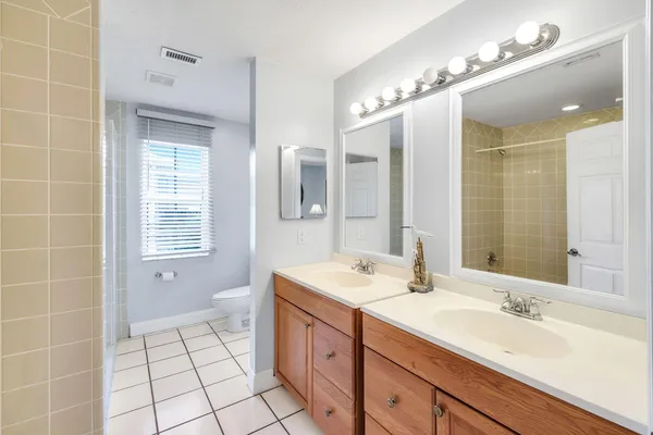 a spacious bathroom with a double vanity sink a mirror and a shower