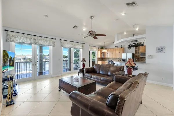 a living room with furniture a chandelier and a glass door