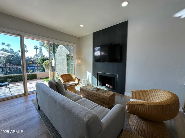 a living room with furniture a flat screen tv and a fireplace