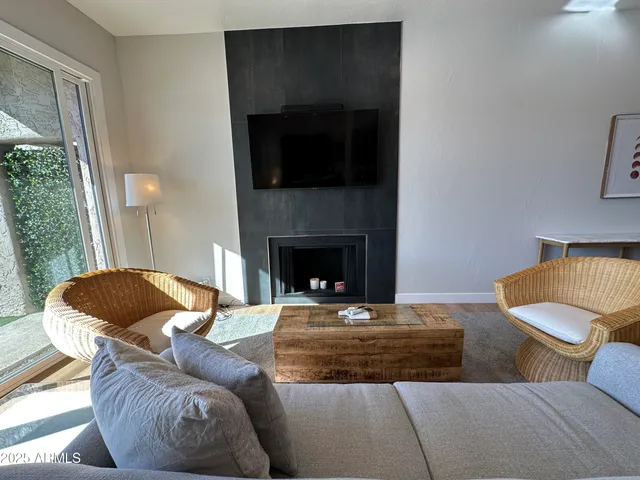 a living room with furniture a fireplace and a chandelier