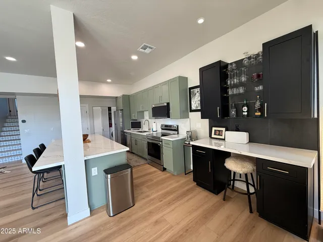a living room with a sink cabinets and piano table with wooden floor