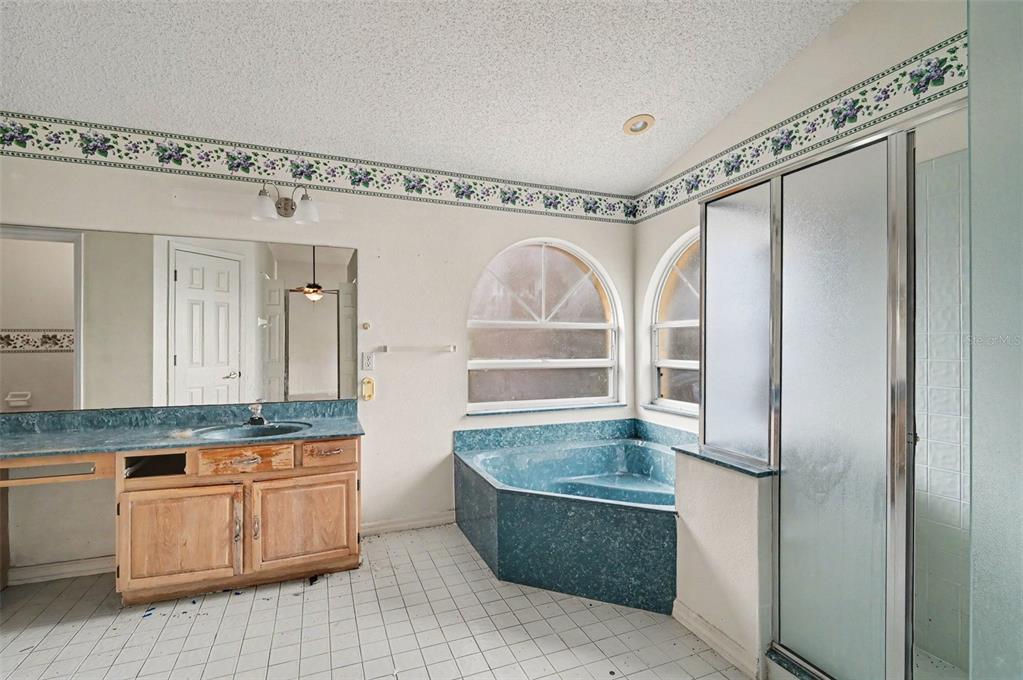 4716 Spaniel Street Orlando, FL 32818 - Photo 16 of 27 a bathroom with a granite countertop sink mirror and a bathtub