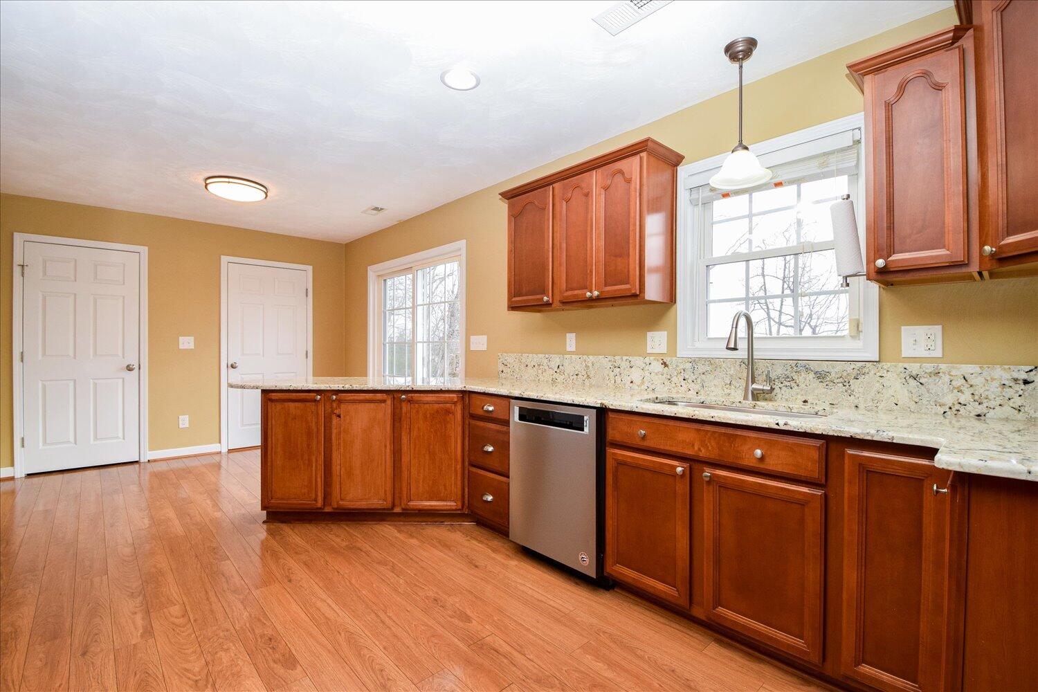 5515 Breckinridge Mill Road Fincastle, VA 24090 - Photo 7 of 31 a kitchen with granite countertop wooden floors a sink stainless steel appliances and cabinets