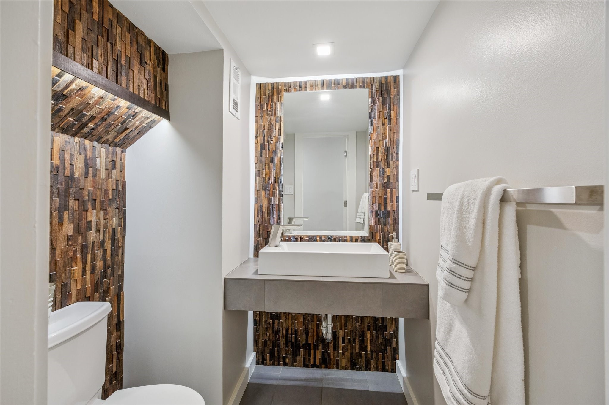 2420 Locke Lane Houston, TX 77019 - Photo 17 of 37 The Powder Room is located just off the Entry and features tile floors, floating vanity and wood-block accent walls.
