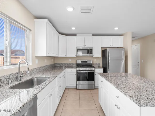 a large kitchen with stainless steel appliances granite countertop a sink stove and refrigerator