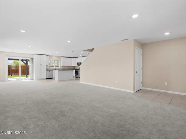 a view of empty room with a kitchen