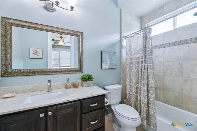 a bathroom with a granite countertop sink a toilet and a mirror