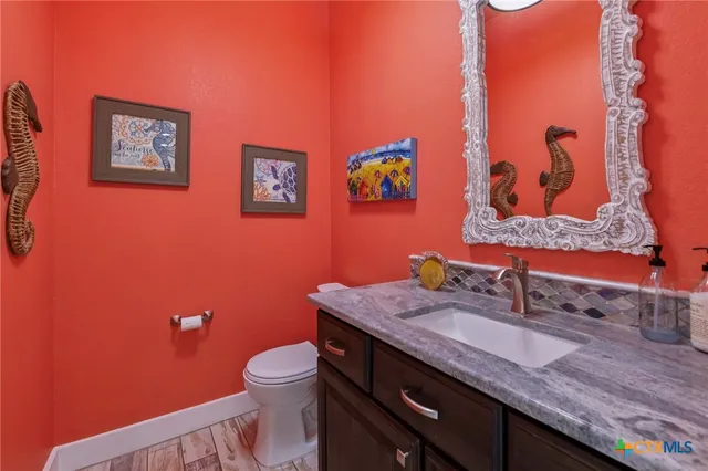 a bathroom with a granite countertop toilet sink and mirror