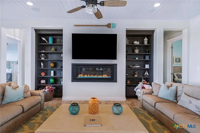 a living room with furniture a flat screen tv and a fireplace