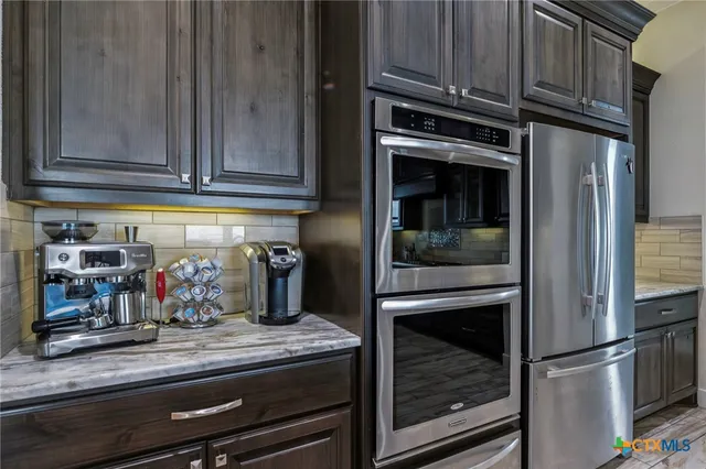 a kitchen with granite countertop stainless steel appliances and wooden cabinets