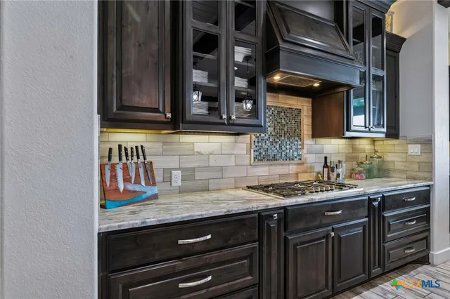 a kitchen with granite countertop a sink and cabinets