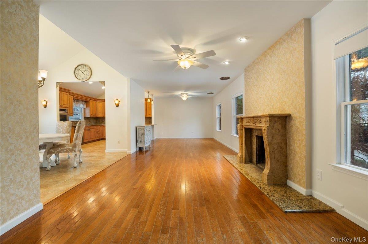 33 Fleets Cove Road Huntington, NY 11743 - Photo 7 of 42 Unfurnished living room with a premium fireplace, a ceiling fan, and light wood-type flooring