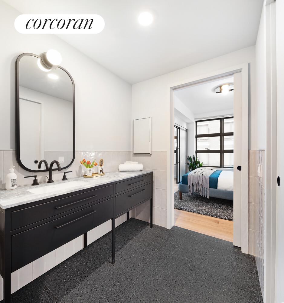 547 West 47th Street, Unit 516 Manhattan, NY 10036 - Photo 6 of 28 a en suite bathroom with a double vanity sink and a mirror