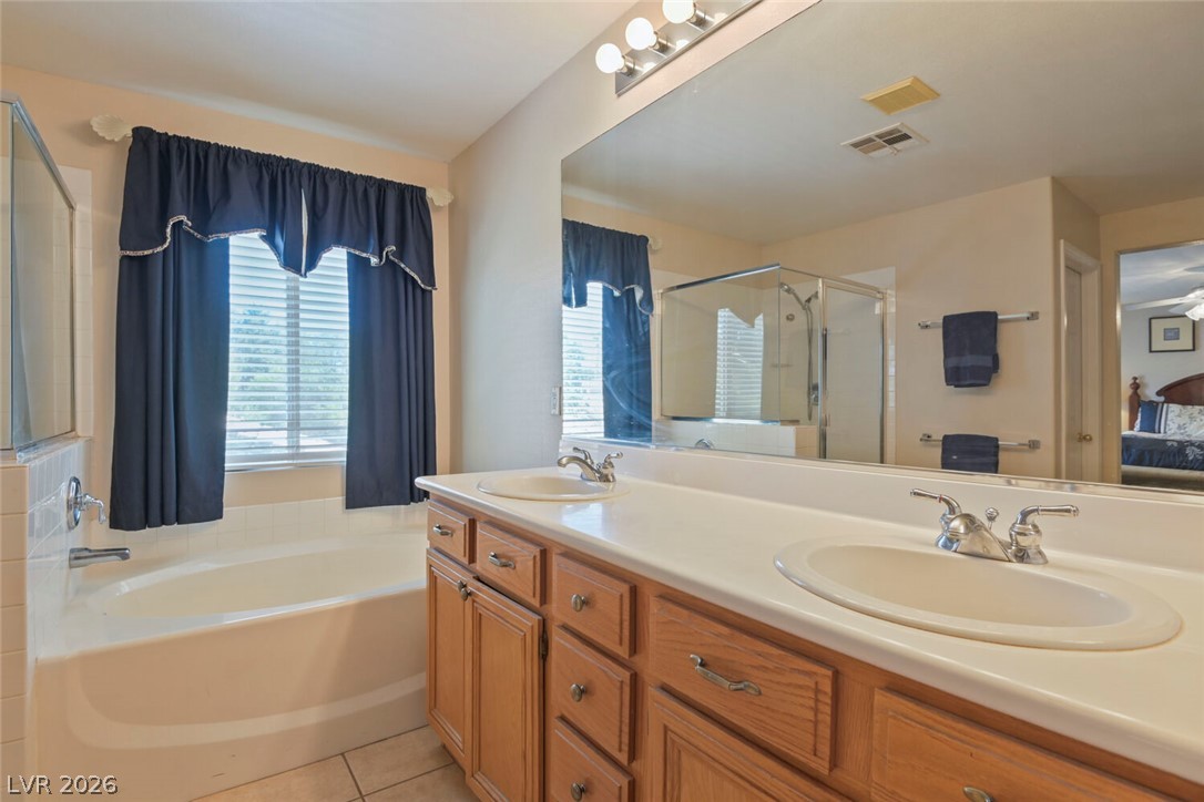 2356 Tilden Way Henderson, NV 89074 - Photo 18 of 30 Relaxing primary bathroom with a soaking tub, glass-enclosed shower, and a generous double vanity.