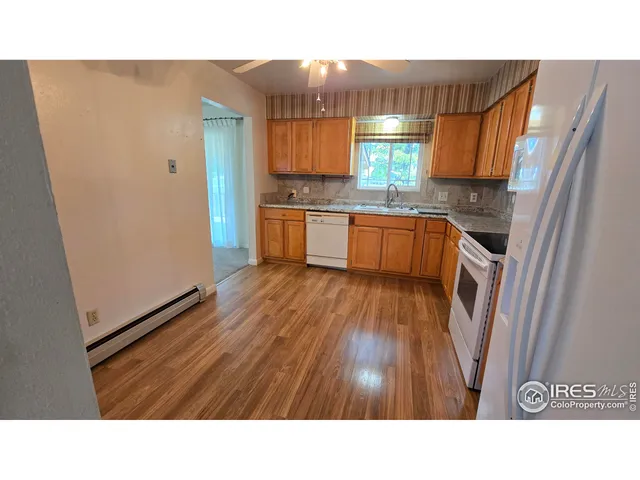 a kitchen with stainless steel appliances kitchen island granite countertop a sink refrigerator and cabinets