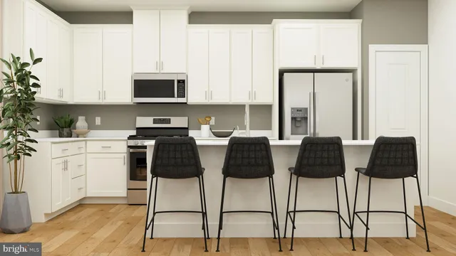 a kitchen with stainless steel appliances kitchen island granite countertop a table chairs and a refrigerator