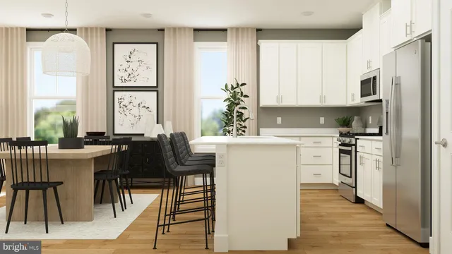 a kitchen with stainless steel appliances kitchen island a table chairs in it and white cabinets